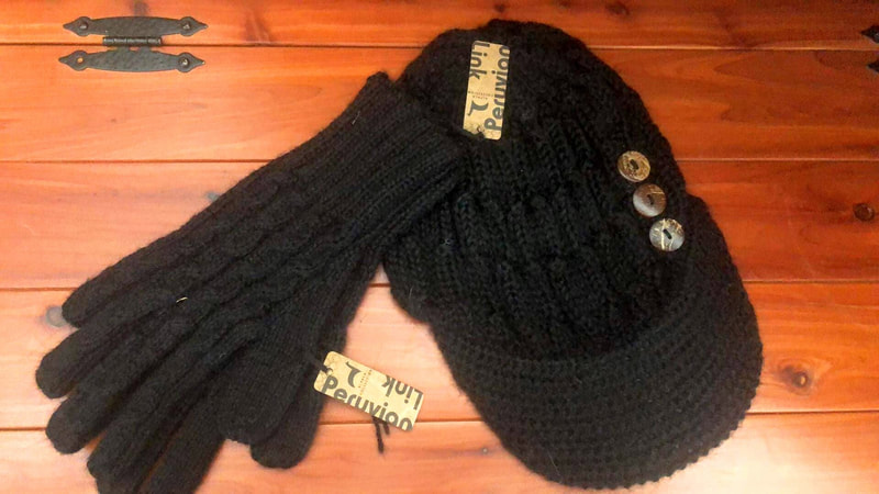 A black alpaca hat and matching black alpaca gloves are for sale at this farm store.